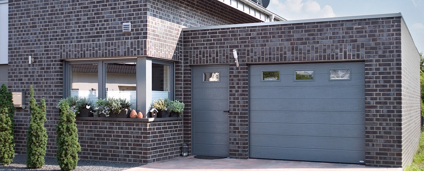 Garagen-Sektionaltor mit ansichtsgleicher Nebentür und Fenster in taubenblau